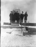 5 herrar vid ett landmärke. [vågbrytare vid Vänersborg?]