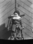 Porträtt av yngling på stol.