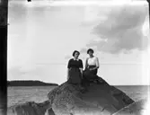 Två unga okända damer på stenen.