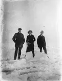 Tre personer ute på isen.