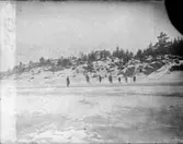 En grupp okända personer på isen.