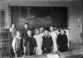 Skolbarn framför svarta tavlan.