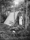 En kvinna och en man vid ett tält i skogen.