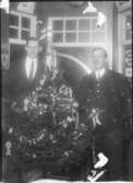 Två män vid en julgran.