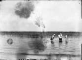Fyra personer tar ett dopp i sjön.