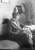 Kvinna läser i tidning.