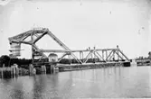 Järnvägsbron över 1916-års kanalled. 
På andra sidan bron ser man att banvallen till järnvägen ligger kvar över kanalen, så fotot är inte senare än 1916. Bron togs i bruk augusti 1916.
Bron är ritad av en svensk, men konstruktionens upphovsman är Joseph Baermann Strauss, vilken ritat den något mer kända Golden Gate-bron i Kalifornien.