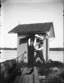 Tre personer vid vattenmätaren på Holmängen, Vänersborg.