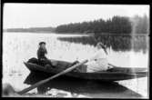 Kvinna ror en eka.
Olof Jonssons text: Norskafrun, 23 juli 1916