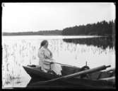 Kvinna sittande i en eka.
Olof Jonssons text: Norskafrun, 23 juli 1916