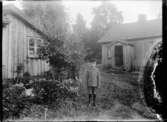 Nils, Hjärtum 1918-01-09, finklädd för att börja skolan. På bilden syns också grönsakslandet med kål och fruktträd.