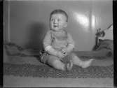Sven Jonsson, Hjärtum 1915-05-14 sitter på en filt i föräldrarnas säng
