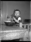 Sven Jonsson, Hjärtum 1915-05-14 står i sin spjälsäng som flyttats intill bordet där han fått någonting i en lerbunke