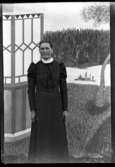 Maria Andersdotter, Naglum 1852-02-08 poserar framför målad bakgrund på Arnstorp (Torpet).