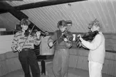 Ungdomarna Peter Sandin, Jonas Persson och Sofia Johansson spelar violin i ABF-stugan i Lindome, år 1985.

För mer information om bilden se under tilläggsinformation.