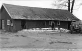 Kyrkstallarna vid Tvärreds kyrka, revs 1970. Hermansson plockar ner teglet. Senare uppfördes bårhus och omklädningsrum för vaktmästaren på platsen.