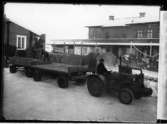 Traktor med 2 vagnar, lastning av tegelsten på järnvägsvagn,   Järnvägsstationen  Vänersborg