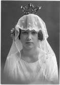Porträtt av en brud i brudklänning, slöja och krona.