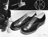 Ett par barnskor med snörning och en leksaksapa.