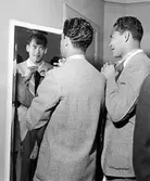 Det brasilianska fotbollslaget Flamengo på Nordiska Kompaniet. Två män i kavajer knyter sina slipsar.