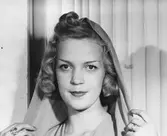 Kvinna i lagd frisyr och slöja.