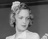 Kvinna i lagd frisyr och rosdekoration.