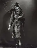 Nordiska Kompaniet. Kvinna i mörk päls. Ljusa handskar. Hårprydnad.