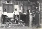 Skomakeri på Östra Långgatan 53, kv Hattmakaren, Varberg. Träskotillverkning i Larsson & Hallbergs verkstad, 1915. Från vänster: Fritjof Hallberg, Birger Bengtsson, Emil Larsson (död på 1920-talet), Johan - springpojke (reste till Amerika).