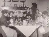 Kaffedrickande hos Mathilda Ranch. Från vänster: Hulda Lindh och Nathalia Alling omgiven av sina döttrar Anna-Stina, Anna-Greta och Ingrid. Pojken är okänd, kvinnorna till höger är troligen anställda pigor.