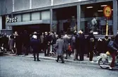 Folksamling utanför postkontoret på Frölundagatan (idag: Brogatan) i Mölndal, 1970-tal.