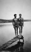 Två baddräktsklädda män poserar ståendes längst ut på en brygga, troligtvis vid Tulebosjön cirka 1930.