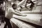 Juris Kuvalds i arbete vid en maskin på Papyrus i Mölndal, år 1990.