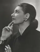 Nordiska Kompaniet. Porträtt av modell i stram frisyr med låg hårknut och stort örhänge. Text på baksidan: 