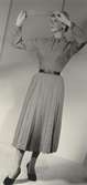 Modell i ylleklänning med veck nedtill och skärp. Från Dior.