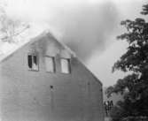 Soab-branden i Stora Götafors den 4 juni 1986. Tre brandmän ser på när det brinner från taket.
