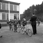 Polisman Snöberg har trafikundervisning för skolbarn på Petersbergs skolgård på 1960-talet.