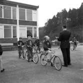 Polisman Snöberg har trafikundervisning för skolbarn på Petersbergs skolgård på 1960-talet.