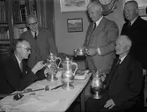 Intendent Nils Ålenius vid Upplandsmuseet besiktigar silverföremål,  i samband med silverutställning hos Uppsala Fabriks- och hantverksförening, Nedre Slottsgatan, Uppsala 1944