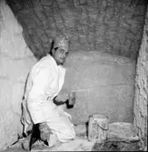 Vinkällaren. Målare Axelsson kalkar källaren från Kungsgatan. Källaren flyttades till museet 1954 av murare Kalle Bodén och Karl Svensson.