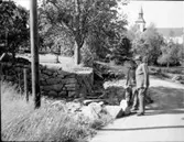 Kyrkogårdsmuren lagas. A. I förgrunden framlidne länsarkitekten Allan Berglund.  Färgelanda