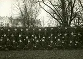 Gruppbild på infanterister. På deras mössor syns kompanimärket 12. Man kan se nummer 24 på axelklaffarna, vilket gör att detta är Norra Skånska infanteriregementet.
