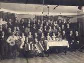 Fotografi från Mölndals Brevduveklubb år 1934. De står troligtvis i Godhem för där hade man små rum.