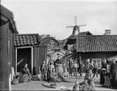 Kvinnor, män och barn vid bodar på Käringön, Bohuslän