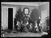 Julfirande.
Barn i tomteluvor.
