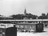 Mölndalsbro-bygget med kontainrar i förgrunden, 1975. Västra delen av Mölndalsbro/Kvarnbygatsviadukten som håller på att byggas, fotograferade söderifrån med Fässbergs kyrka i bakgrunden.