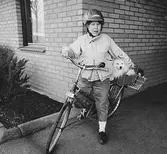 Inga-Lill Lipovsék på cykel med sin hund Chico på pakethållaren. Bild som användes vid utställningen 