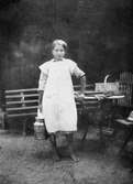 Helga Rohman (född Johansson) står barfota och håller en mjölkspann i högra handen, 1920-tal. Helga arbetade på Gunnebo slott.
