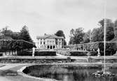 Gunnebo slotts huvudbyggnad och södra trädgården från södra sidan av dammen. 1960-tal.