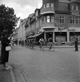 En cykeltävling går genom Huskvarna. Här förbi Nyléns skor på Esplanaden.