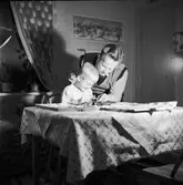 Tom Andersson sitter vid bordet och bygger med Mecano, pappa Evert hjälper till.